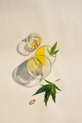 Cannabis leaves, CBD oil and capsules in transparent labware