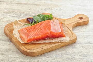 Raw salmon fillet over board