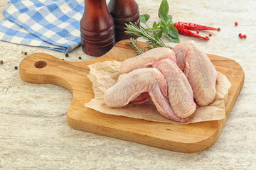 Raw chicken wings over board
