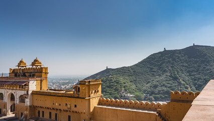 The ancient Amber Fort is built of orange sandstone. The arched entrance and domes are visible. A...