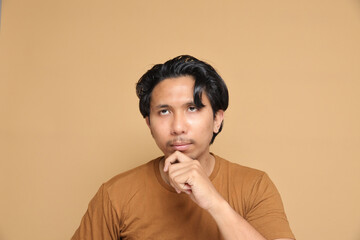 Asian male with messy hair expressing multiple emotion over plain background.