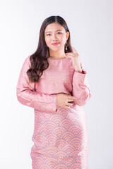Obraz premium A portrait of a young Indonesian lady looking beautiful wearing traditional Malaysian or Indonesian wear isolated on a white background. Idul Fitri fashion concept.