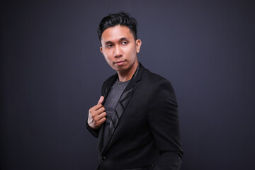 Asian male in corporate oufit over dark background.  Office business concept.