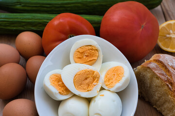 chicken eggs boiled very fresh, with a round yellow or orange yolk and a well-formed white. eggs on a wooden table