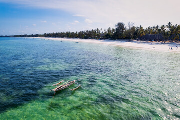 Indulge in a luxurious getaway at Zanzibar's Kiwengwa beach, where the white sand, turquoise waters, and palm trees create a serene and refreshing atmosphere for a truly memorable vacation.