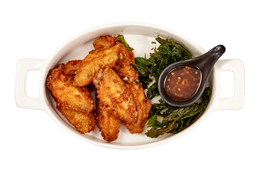 Top view of Crispy Fried Chicken wings with Crispy Basil Leaves and Chicken dipping sauce (sweet) isolated on white background. popular appetizers.