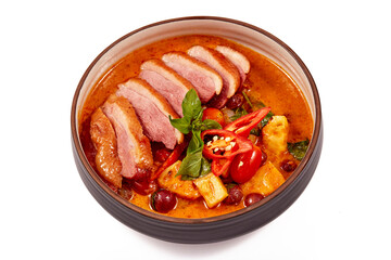 Red curry with roasted duck isolated on white background, this food contains such as red curry paste, chili, tomato and pineapple.