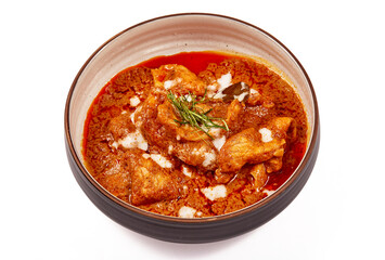 Panang pork curry with coconut milk and sliced kaffir lime leaves in a bowl isolated on white background, Panang curry is a very popular Thai dish.