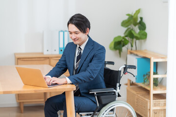 車椅子に座り仕事をするビジネスマン
