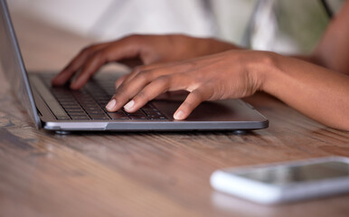 Hands, laptop and typing on wooden table for communication, email or social media. Hand of African...