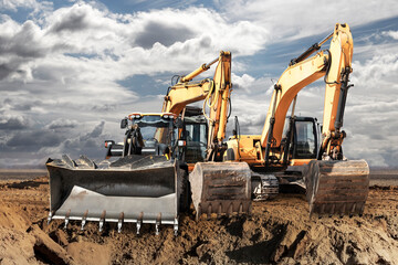 Bulldozer or loader moves the earth at the construction site against the blue sky. An earthmoving...