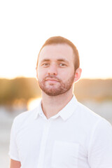Fototapeta premium young bearded man in white shirt on beach in summer