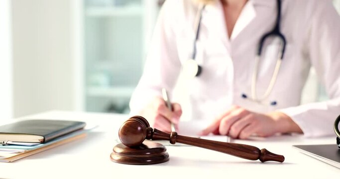 Judicial gavel with stethoscope on table doctor cardiologist writes notes