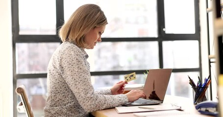 Woman manager holding credit card while making online payment