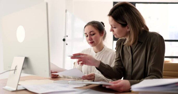 Seo supervisor shows intern how to work on computer in office