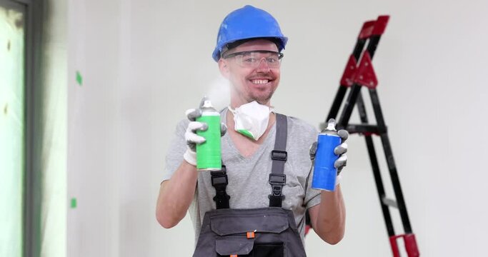 Smiling construction worker holding two cans of paint