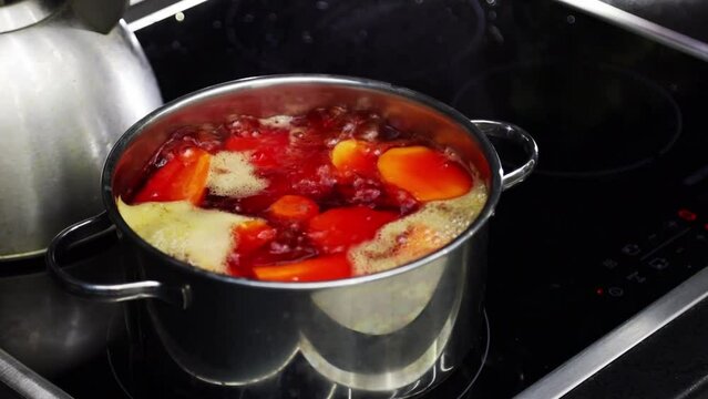 Boiling water in a saucepan on an electric stove. Boiled red beetroot in an iron pan