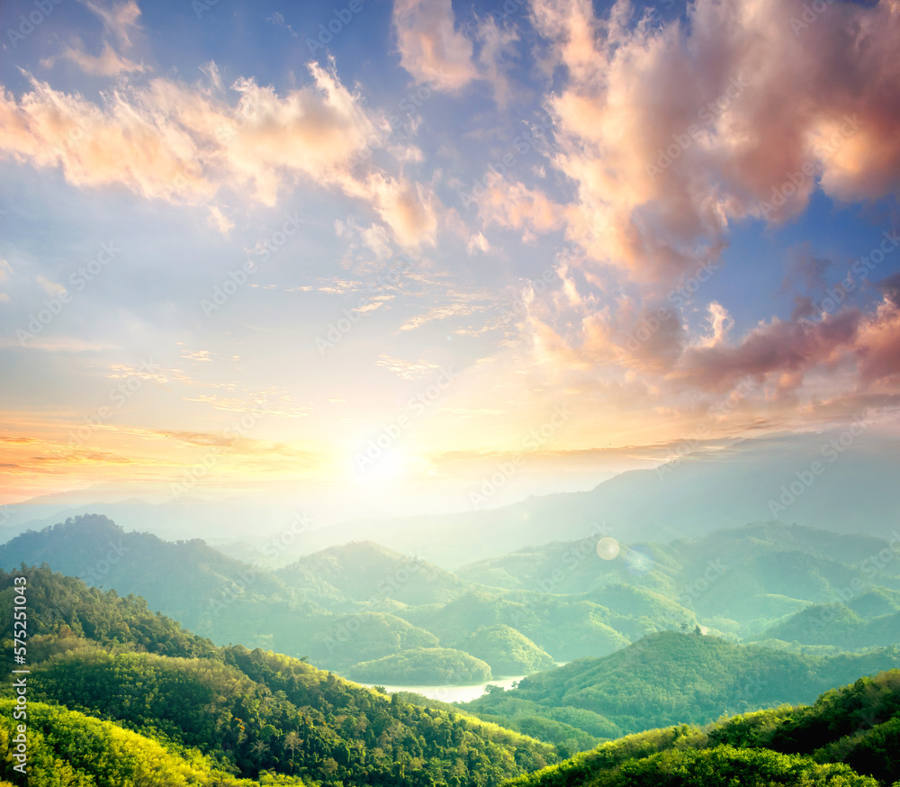 Wall mural sunrise over green forest with mountains and river background