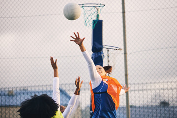Netball, goal shooting and defense of a girl athlete group on an outdoor sports court. Aim, sport game and match challenge of a black person with a ball doing exercise and training in a competition - obrazy, fototapety, plakaty
