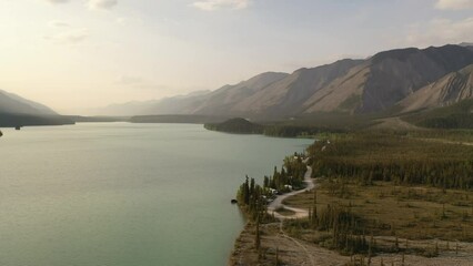 Aerial view of campground, RV park on the lakeshore. Services along the Alaska Highway. Travel, adventure, journey concept. Northern Rocky Mountains, Muncho Lake Park in British Columbia, Canada