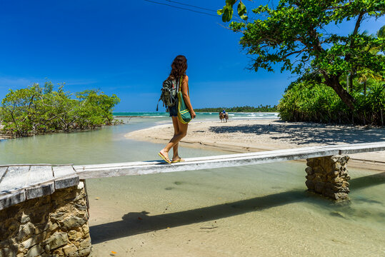 Young woman walking on tropical beach in south Bahia, Brazil