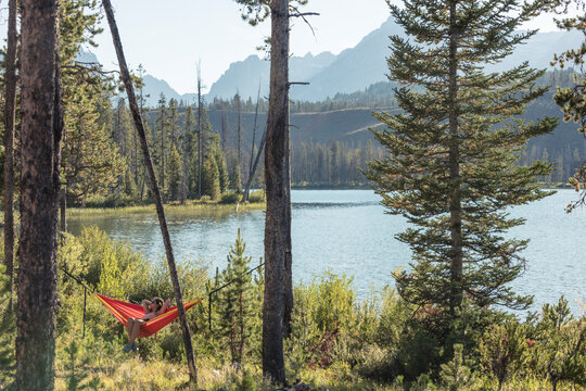 Woman relaxing in hammock next to Little Redfish Lake, Stanley, Idaho, USA