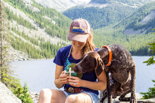 Woman and her dog have a snack while hiking