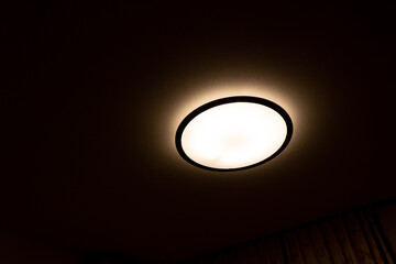 暗い部屋で光る円形のシーリングライト