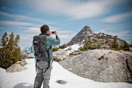 A backpacker takes a picture of Needle Peak