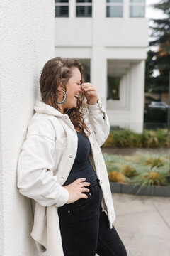 White woman outside dressed in black and white, laughing