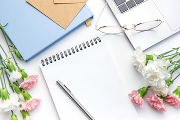 Modern white office desk table with laptop, notebook and other supplies.