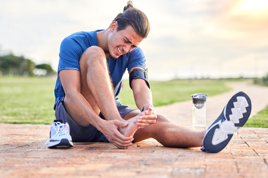 Fitness, injury and foot pain with man in park for muscle spasm, inflammation and joint problem. Running, workout and exercise with athlete and sports emergency for health, suffering and broken ankle