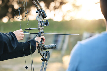Archery, closeup and target training with an instructor on field for hobby, aim and control. Arrow,...