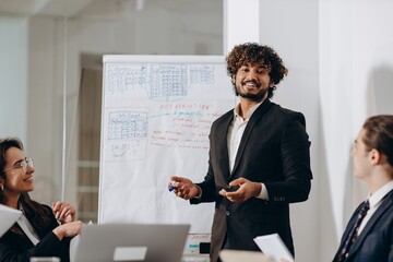 Smiling businessman doing presentation with whiteboard. Company manager presenting new business strategy to colleagues