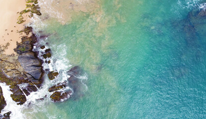 Aerial view of the ocean coast and sandy sea beach. Beautiful water background texture for tourism and advertising. Tropical coast