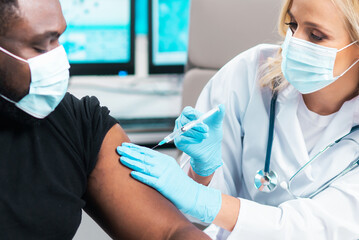 Professional doctor makes a coronavirus vaccine using a syringe and hypodermic needle. Professional...