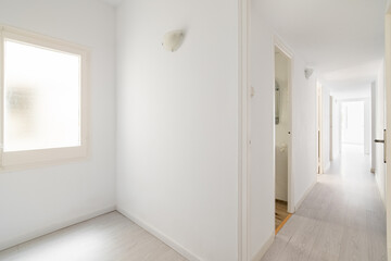 View from the entrance to new empty apartment after renovation in white tones with wooden floor. Cozy apartment in new building with modern minimalist design from the developer