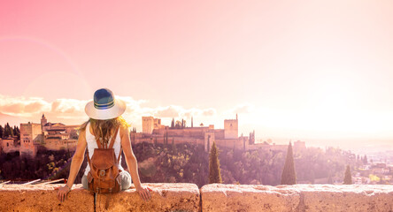 Tourist looking at  Ancient arabic fortress Alhambra in Granada at sunset- Spain