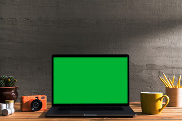 Chroma key green screen laptop on table with film camera and film roll