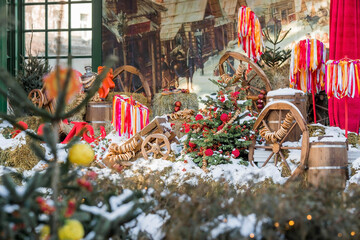 Naklejka premium Decorations on Tverskaya Street in honor of the celebration of the traditional Russian holiday Maslenitsa. Carts, hay, barrels, samovars, bagels and trees with colorful ribbons.