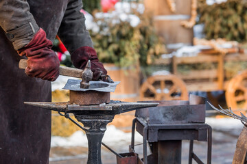 Moscow seasons. Traditional craft. The work of a blacksmith with metal at the celebration of Maslenitsa (Maslenitsa Week). Russian traditions. Tverskaya Street. Moscow. Russia
