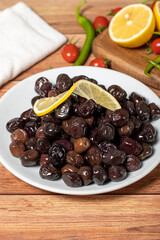 Black olive. Fermented olives and lemon slice in plate. Mediterranean flavors