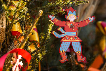 Moscow seasons. Decorations on Tverskaya Street in honor of the celebration of the traditional Russian holiday Maslenitsa. An image of a petrushka toy on a Christmas tree with multicolored ribbons.