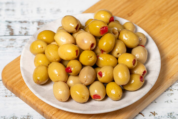 Stuffed olives. Green olives stuffed with dry peppers on a wooden background. Mediterranean flavors