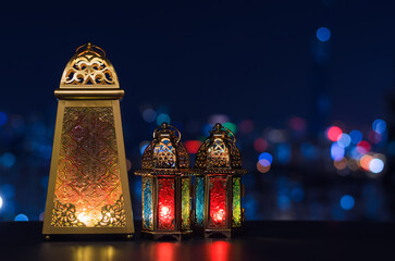 Selective focus on big lantern with night sky and city bokeh light background for the Muslim feast of the holy month of Ramadan Kareem.