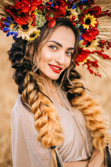 A beautiful young Ukrainian woman in a dress stands in a wheat field. The concept of independence of Ukraine.