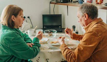 elderly couple sitting at a table and having lunch