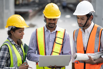 India engineer man holding laptop computer with team engineer at precast site work	
