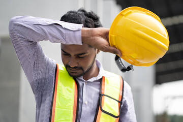 Portrait tired India engineer man at precast site work	