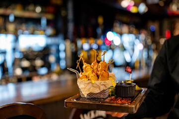 Waiter hold plate with corn dog in restaurant